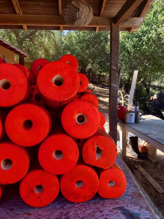 stack of orange painted buoys for spiny lobster fishing