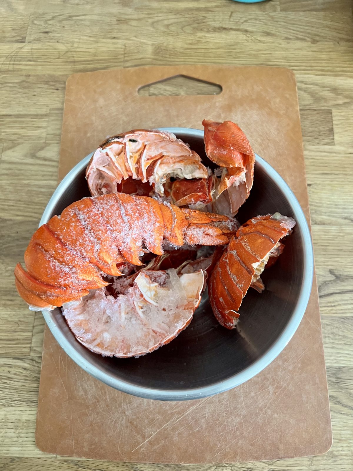 Frozen spiny lobster tail shells in a silver bowl