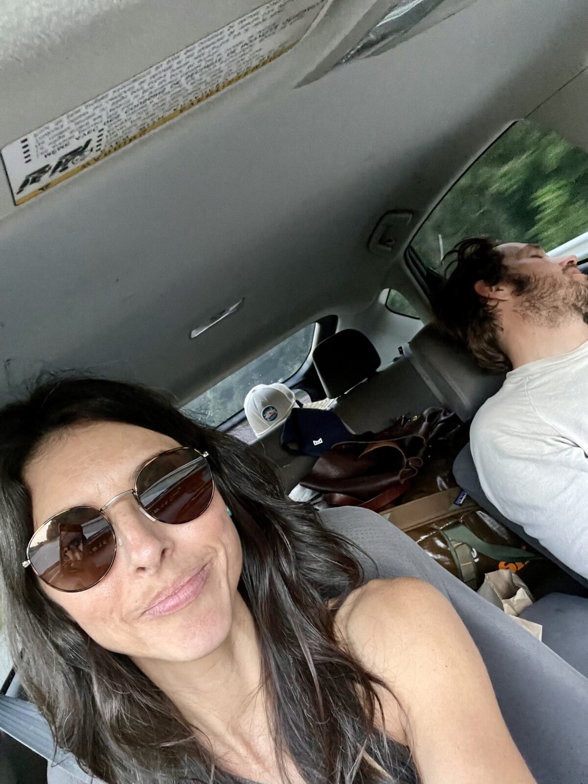 Woman driving a packed Prius with sleeping husband in passenger seat